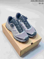 Pair of light gray and dark accent SREGIEK sneakers shown on a box.