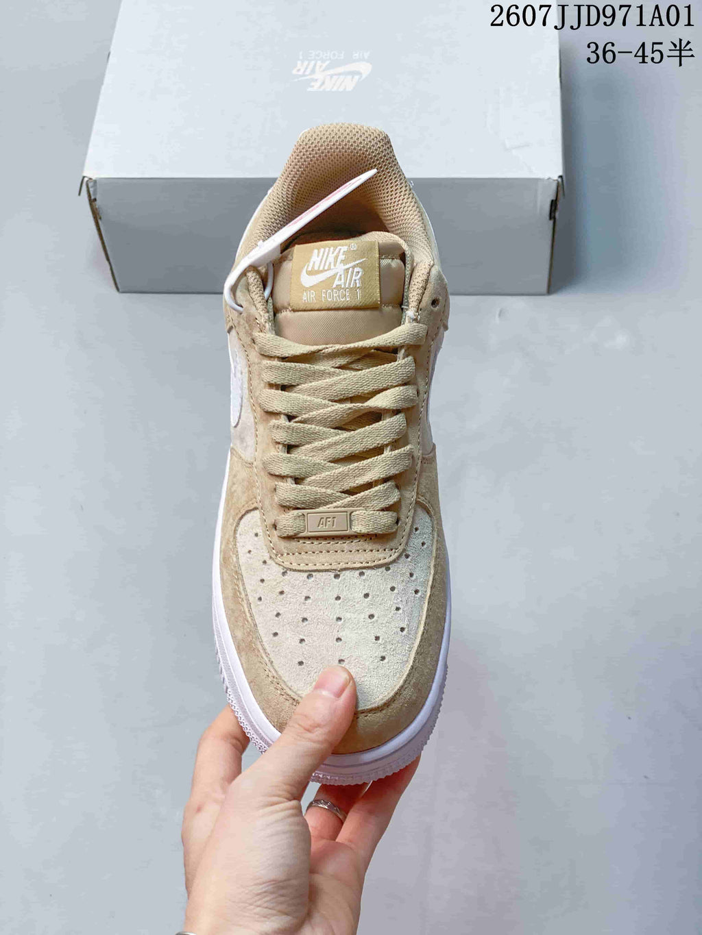 Front view showing the perforated toe and laces of a beige and white Nike Air Force 1 '07 sneaker