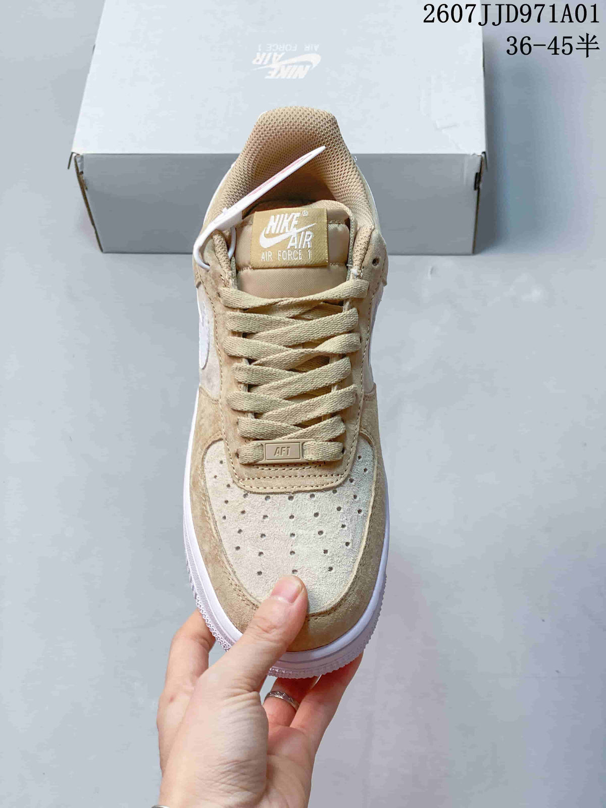 Front view showing the perforated toe and laces of a beige and white Nike Air Force 1 '07 sneaker