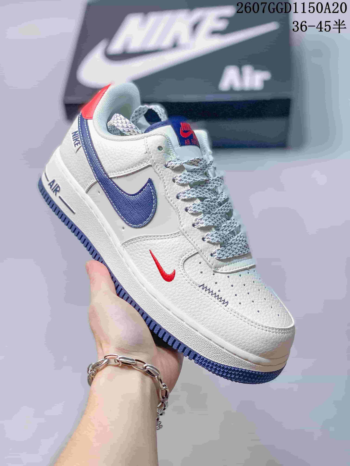 Close-up of a white Nike low-top sneaker with blue side branding, red heel detail, patterned laces, and a visible Air-marked midsole.