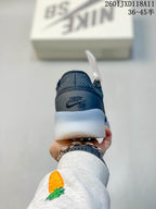 Rear view of a dark gray Nike SB shoe showing the branded heel panel and translucent midsole.