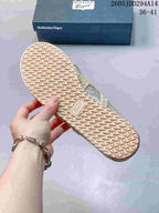 Underside of an Onitsuka Tiger sneaker showing the textured rubber outsole and central brand mark.