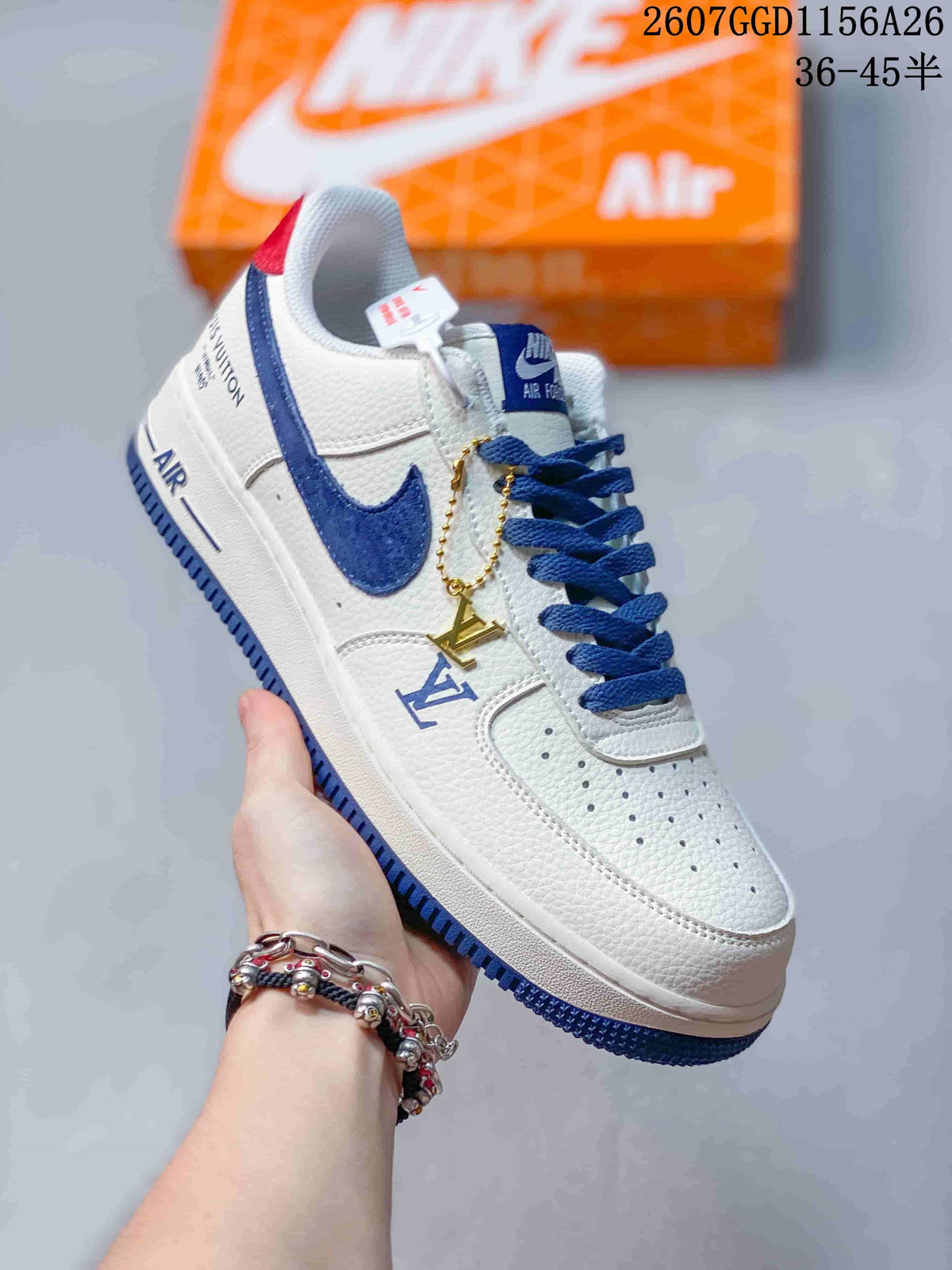 Angled side view showing the white and blue sneaker, decorative side markings, hanging charm, and red heel accent.