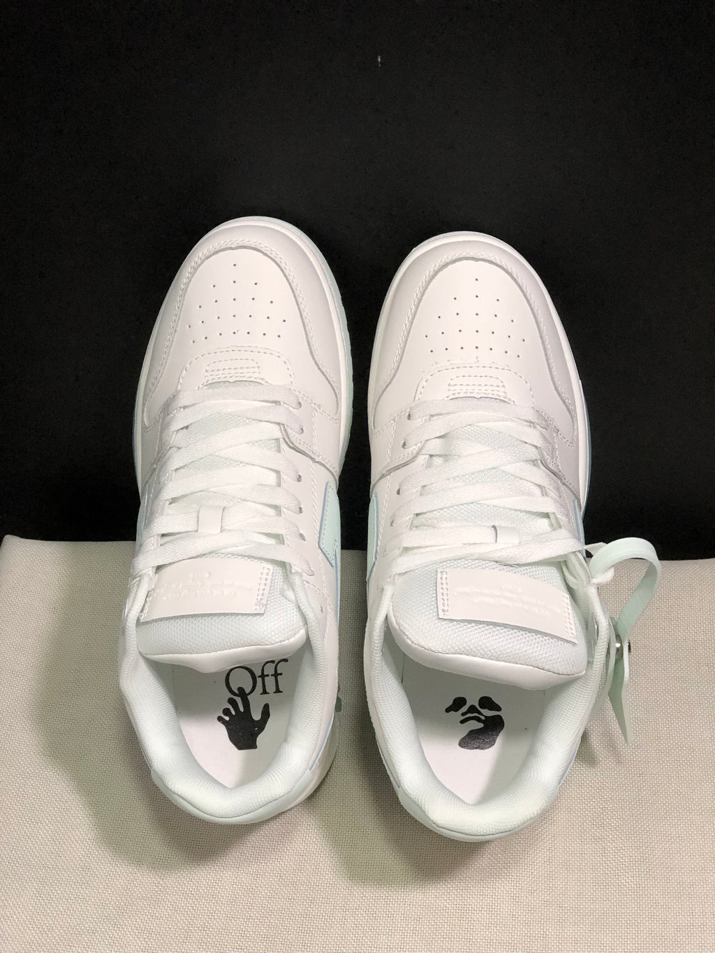 Top-down view showing the perforated toe boxes, white laces, tongues and branded insoles.