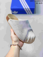 Angled view of a grey adidas Adimule mule slide with white toe covering and tan footbed.