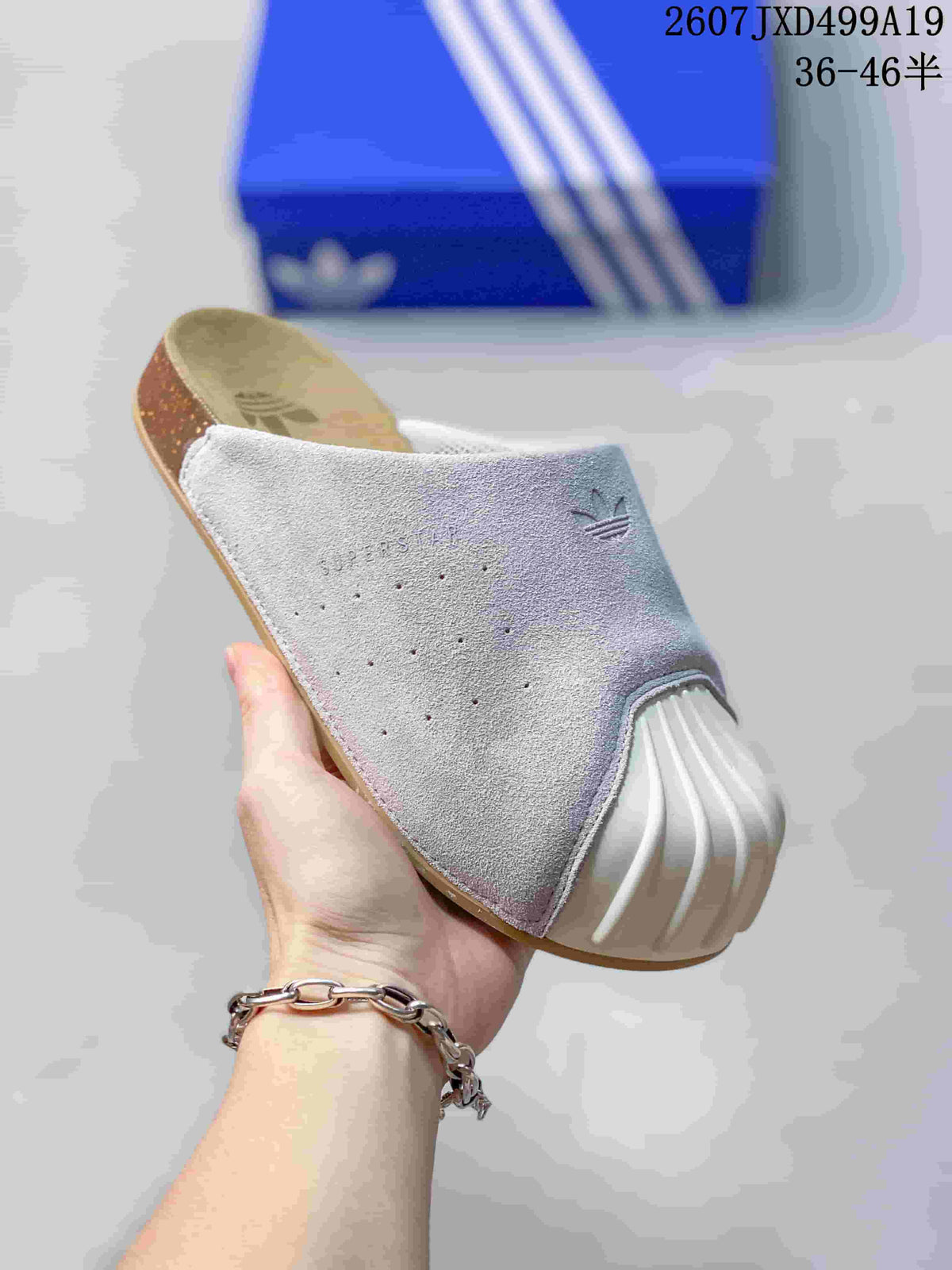 Angled view of a grey adidas Adimule mule slide with white toe covering and tan footbed.