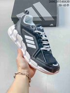 Angled view of the dark navy and gray mesh shoe with white laces and sculpted white sole.