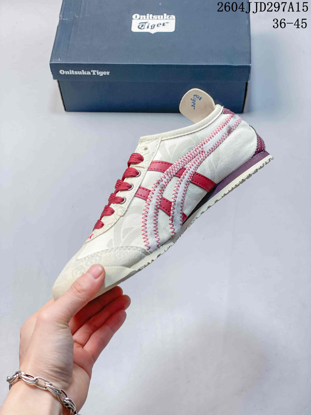 Side profile showing the cream upper, red stripes, stitching, and low-top shape