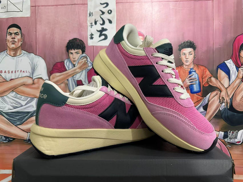 Angled view of the pink New Balance U370 sneakers showing the side detailing and heel
