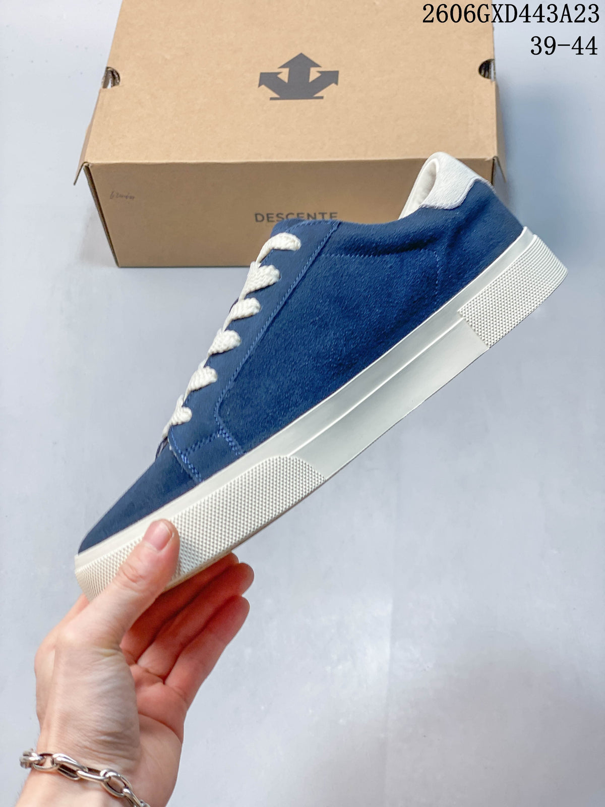 Side view of the blue DESCENTE sneaker with a cream sole
