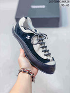 Close side view of a black low-top sneaker showing the contrasting light trim and side logo.