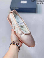 Angled close-up of the pink metallic shoe showing the rounded toe, white side stripes, and flat outsole.