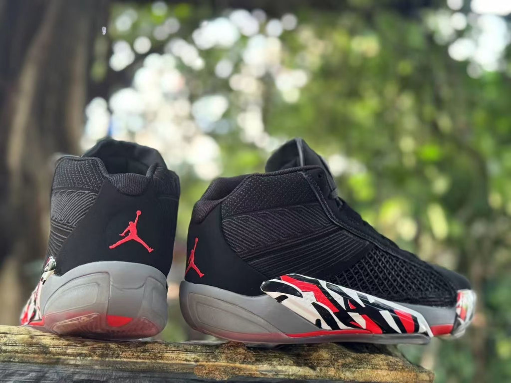Rear and side view of Jordan XXXVIII shoes with red heel logos