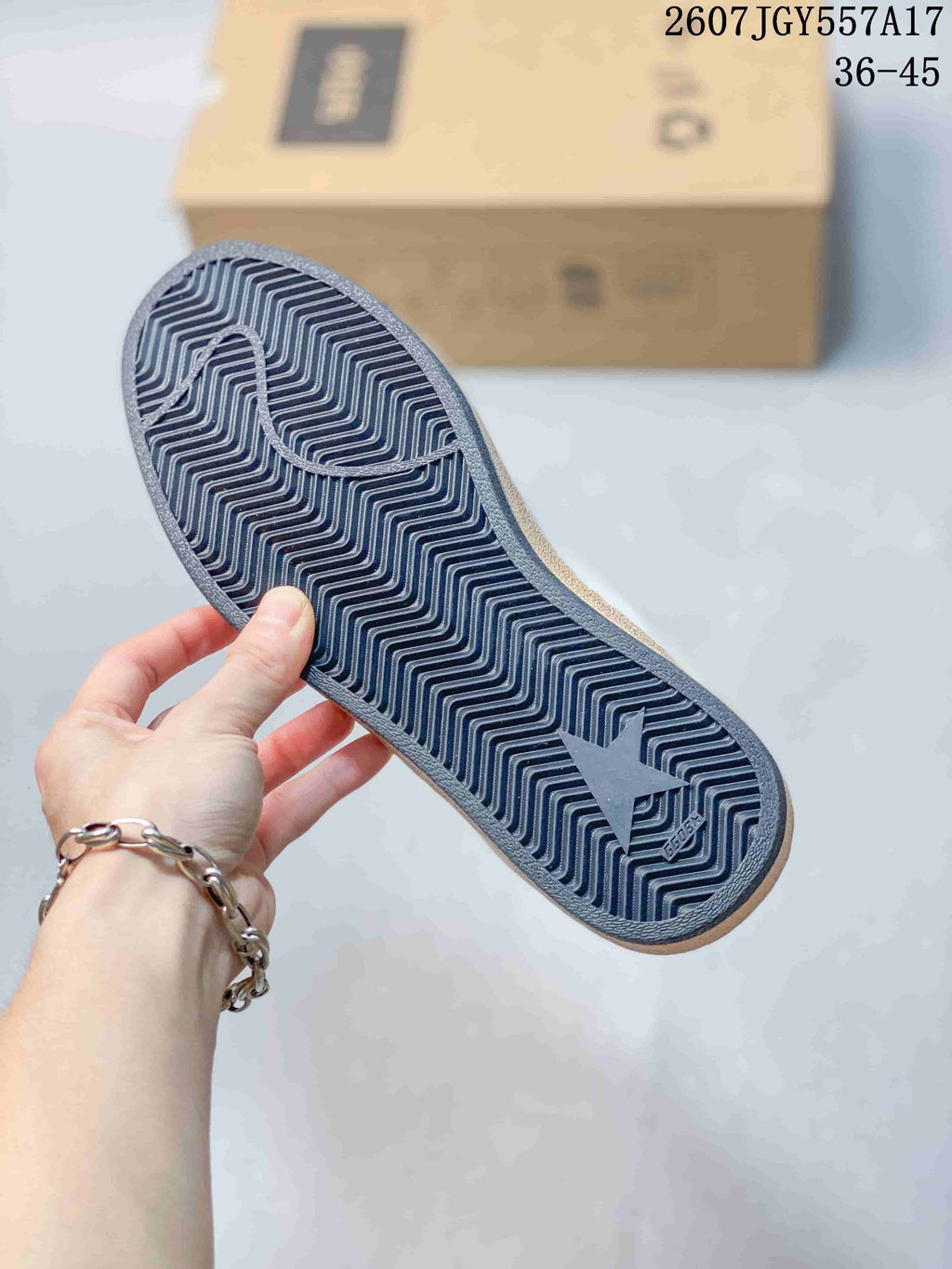 Bottom view showing the dark patterned outsole of a Golden Goose Ball Star sneaker.