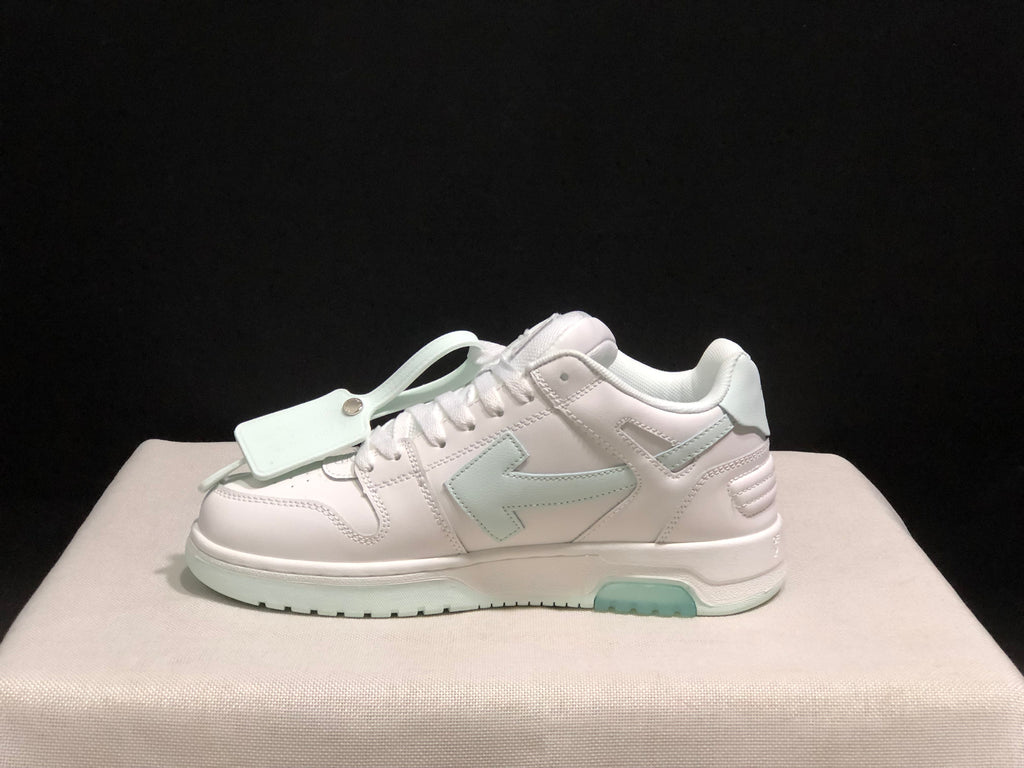 Side profile showing the low-top silhouette, layered stitched panels, decorative hangtag and pale mint outsole sections.