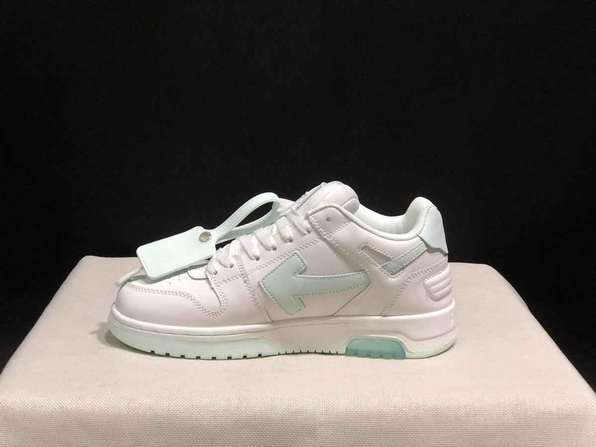 Side profile showing the low-top silhouette, layered stitched panels, decorative hangtag and pale mint outsole sections.