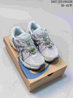 Pair of light gray ASICS Gel-Kahana 8 FL sneakers displayed on a shoebox, showing black detailing, green lace accents, and the style code 2607JDY186A26.