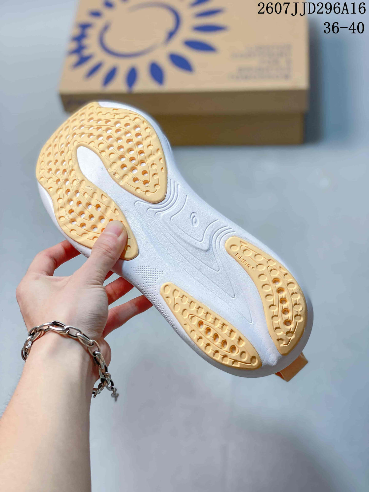 Underside view of the shoe showing a white outsole with gum-colored traction sections and molded sole details.