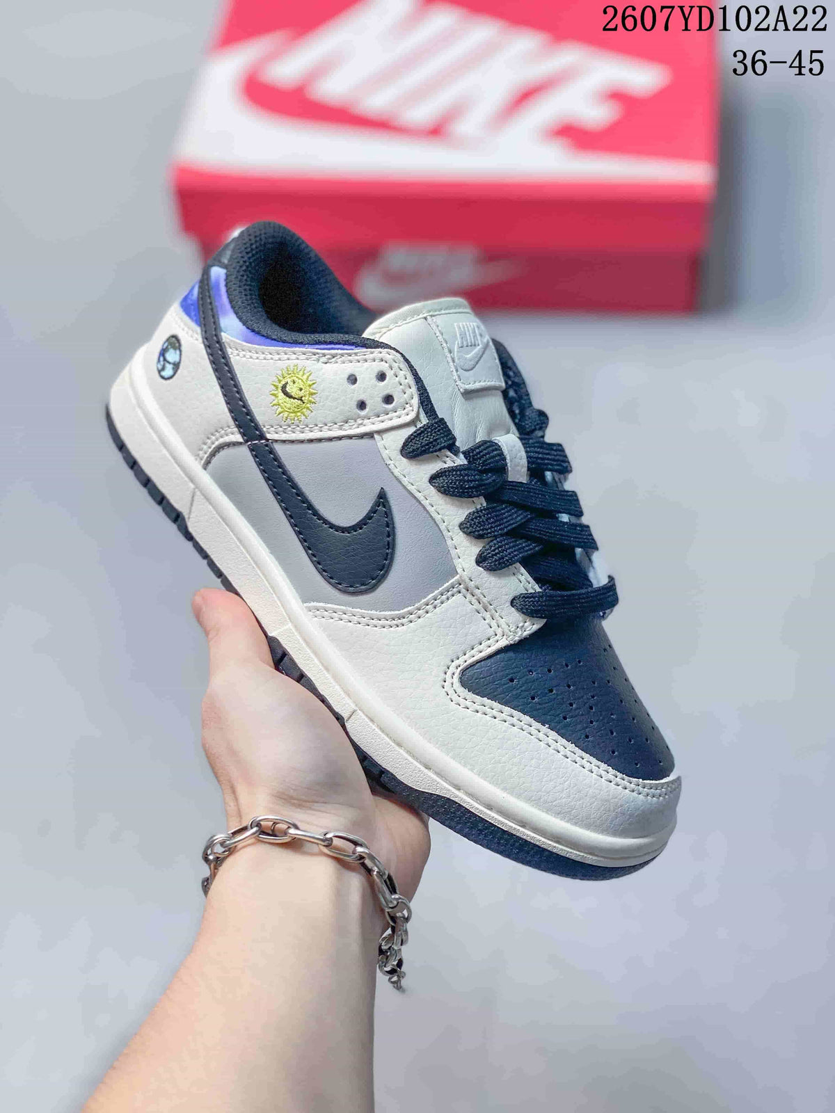 White and navy Nike SB Dunk Low Pro sneaker with dark laces and contrasting side panels.