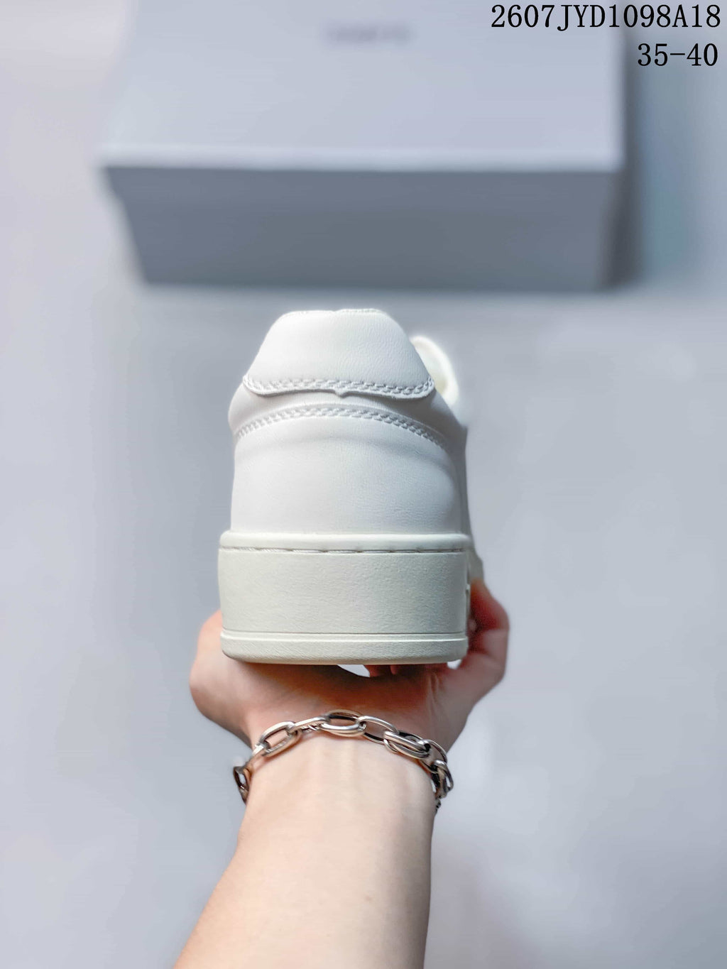 Rear view of a white low-top sneaker showing the padded heel and layered heel construction.