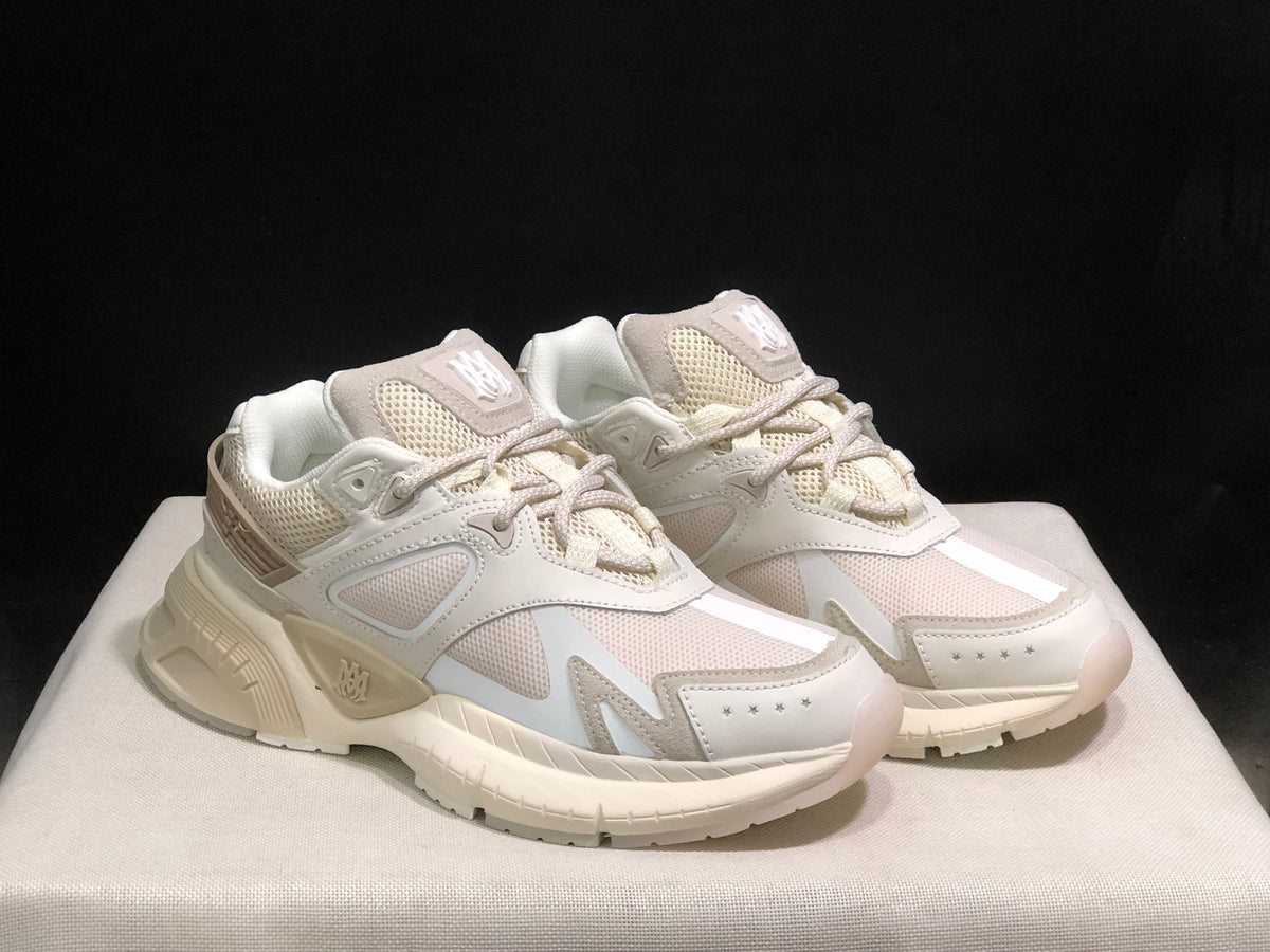 Three-quarter front view of the bone white sneakers showing the toe overlays, side panels and thick outsole.
