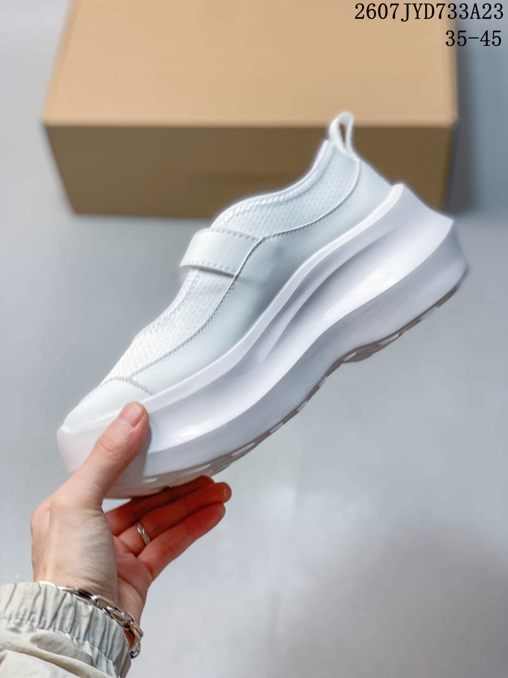 Side view of the white Mary Jane-style sneaker showing the strap and layered platform sole.
