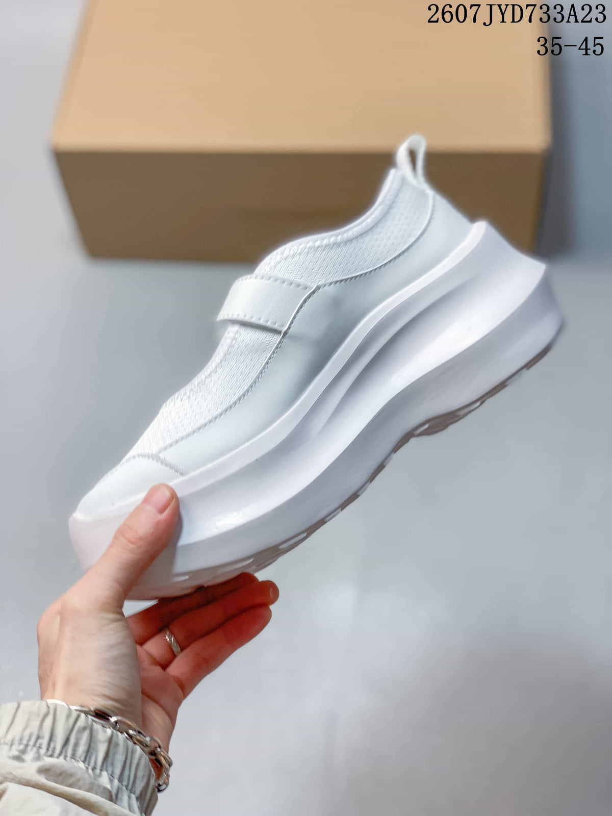 Side view of the white Mary Jane-style sneaker showing the strap and layered platform sole.