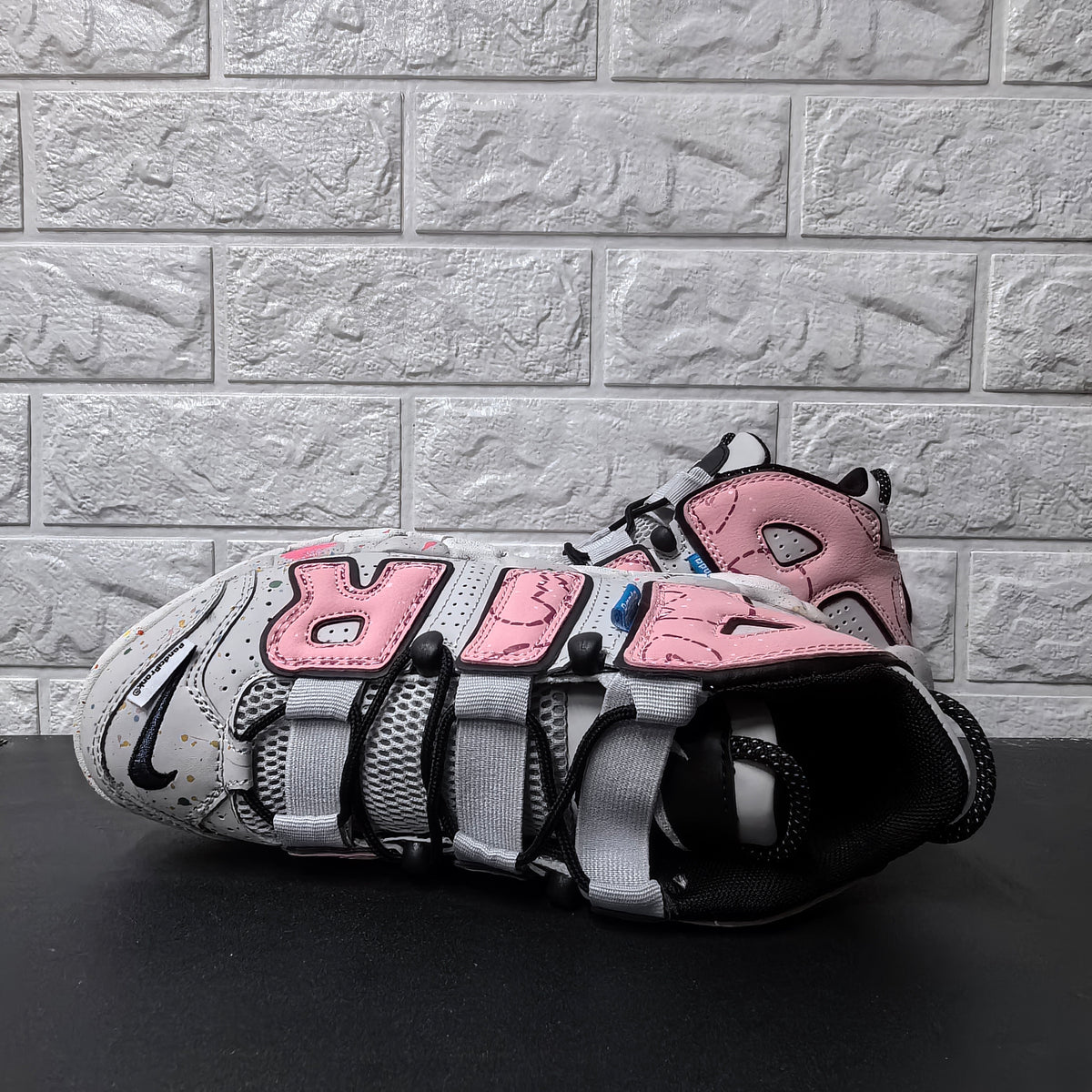 Top view of sneaker showing mesh tongue, black laces, and wide grey lace loops