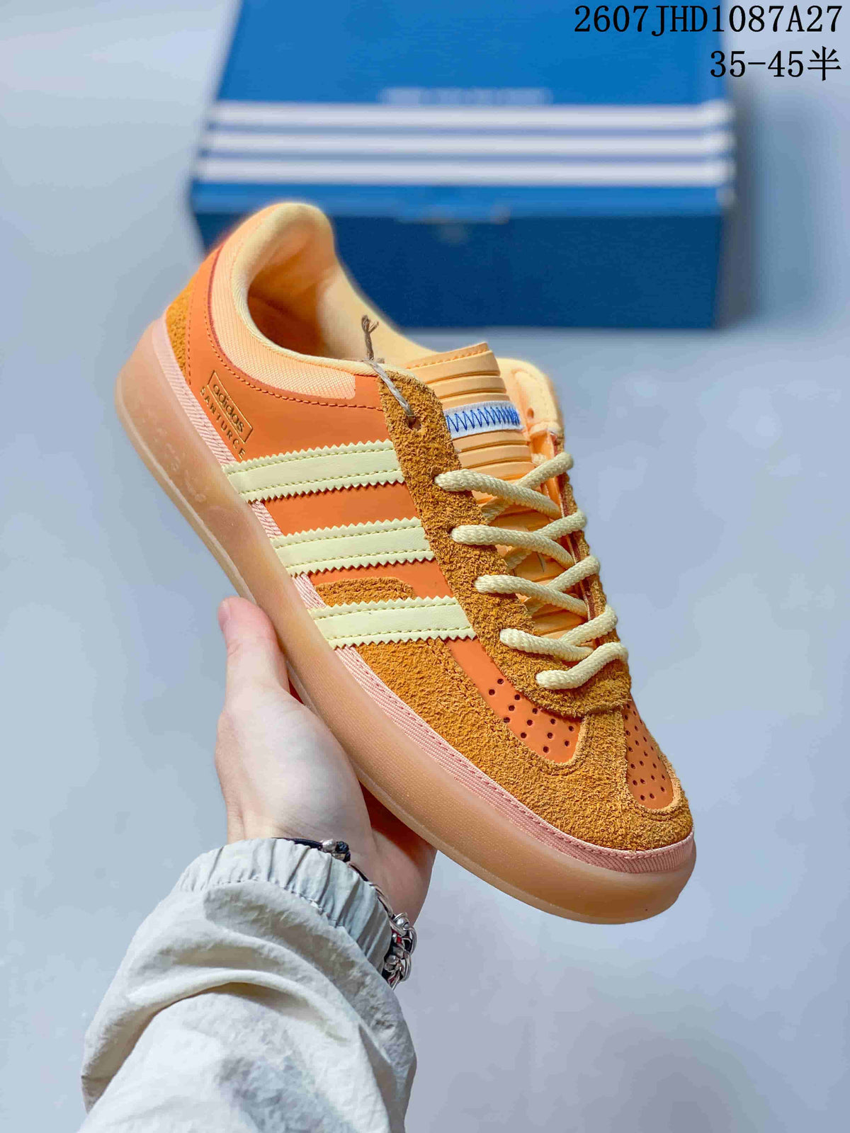 Angled side view showing the orange upper, cream three stripes and Samba side branding.