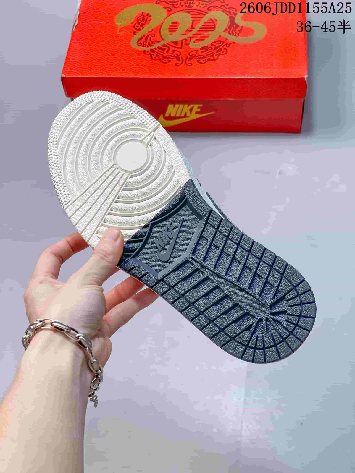 View of the sneaker outsole showing a circular traction pattern and dark navy tread sections.