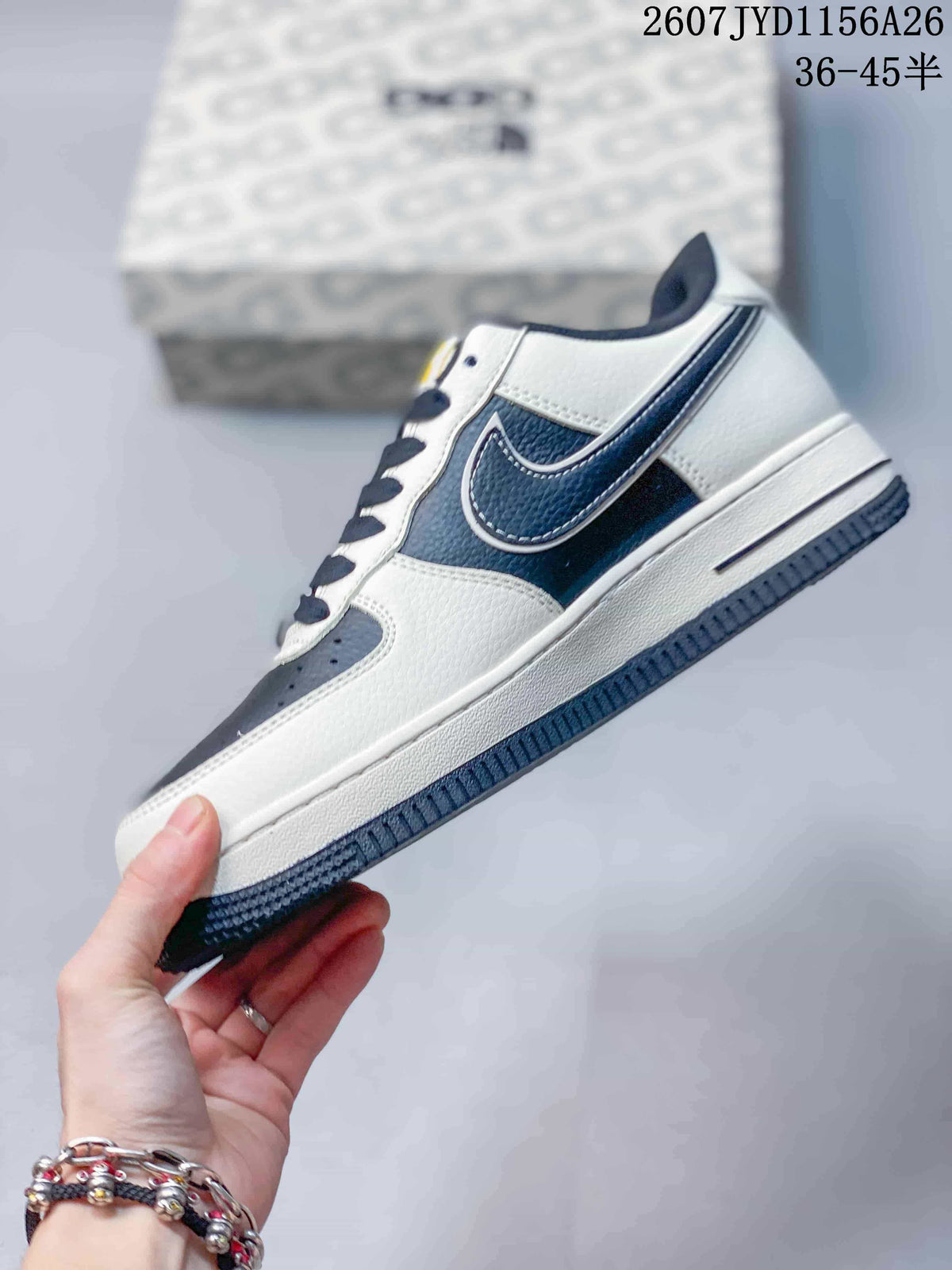 Side profile of a white and navy low-top Nike Air Force 1 sneaker with a layered side swoosh and dark outsole.