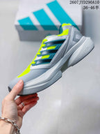 Side view of the adidas Equipment Adios Pro running shoe showing layered grey and teal side panels, neon yellow details and a sculpted sole.