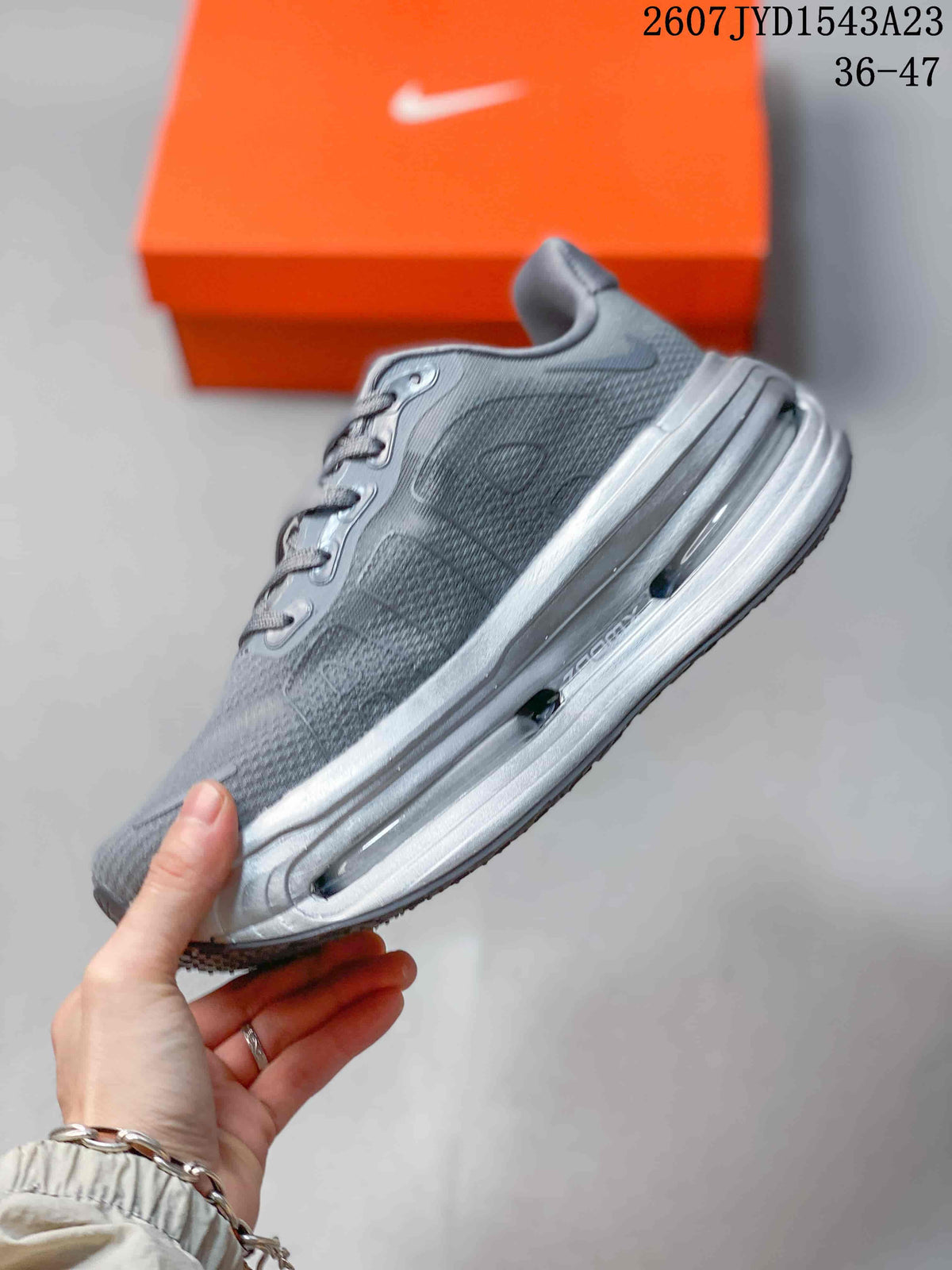 Side profile of the Nike Vomero Premium sneaker showing the textured upper and sculpted silver-toned midsole.