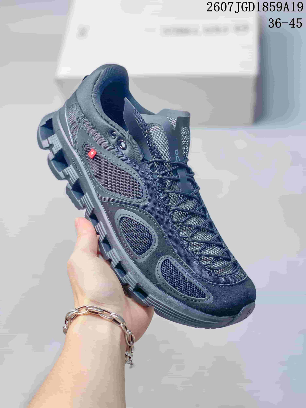 Charcoal and dark gray On sneaker with matching laces, mesh panels, and a dark segmented outsole.