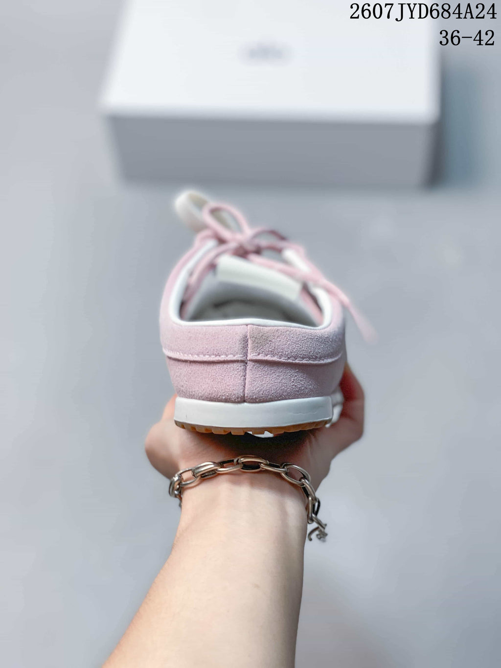 Rear view of the pink sneaker showing the heel construction, white midsole, and tan outsole.