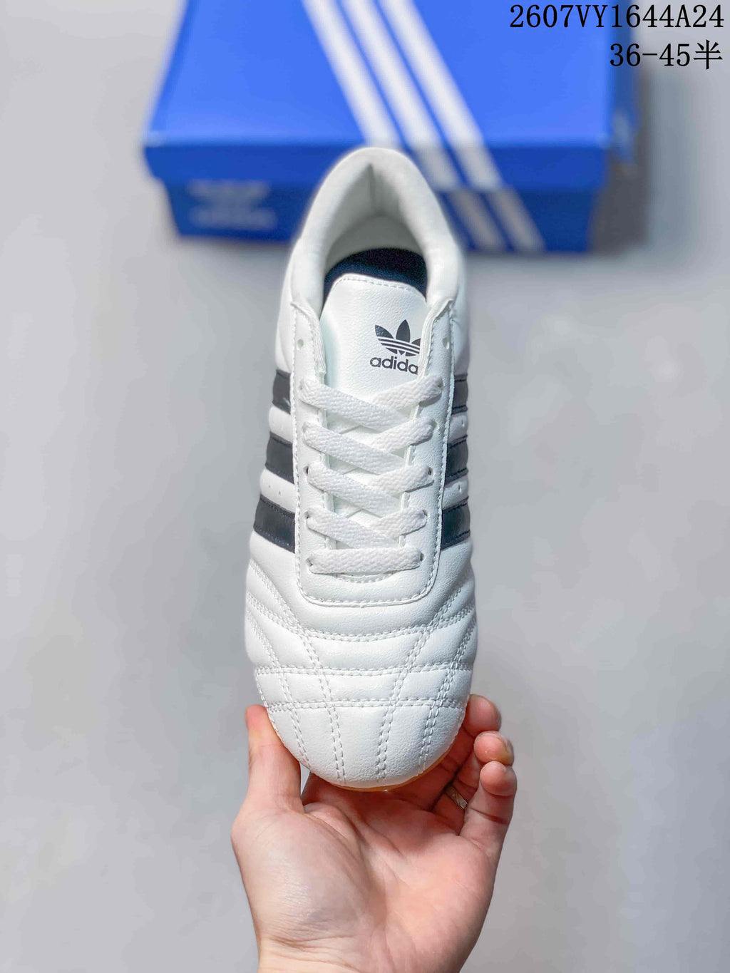 Top view of a white adidas Taekwondo sneaker with white laces, padded collar, stitched toe panels, and Trefoil tongue branding.