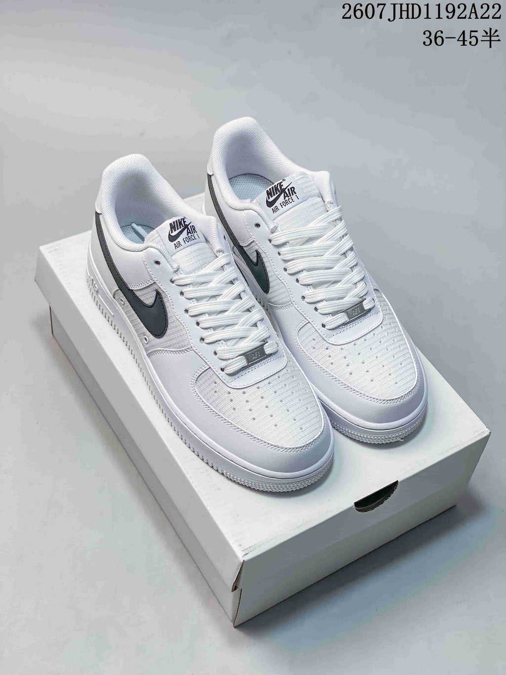 Pair of white and black Nike Air Force 1 Low '07 style sneakers displayed on a shoe box.
