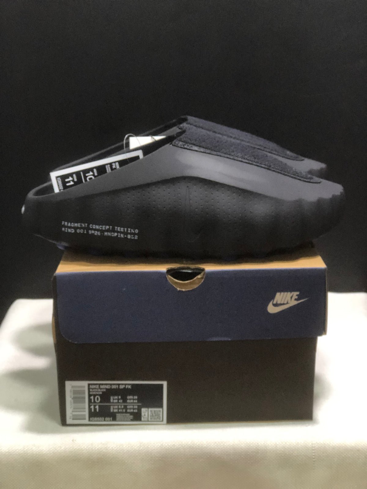 Side view of the black Nike Mind 001 slide with perforated side detailing and visible shoebox label.