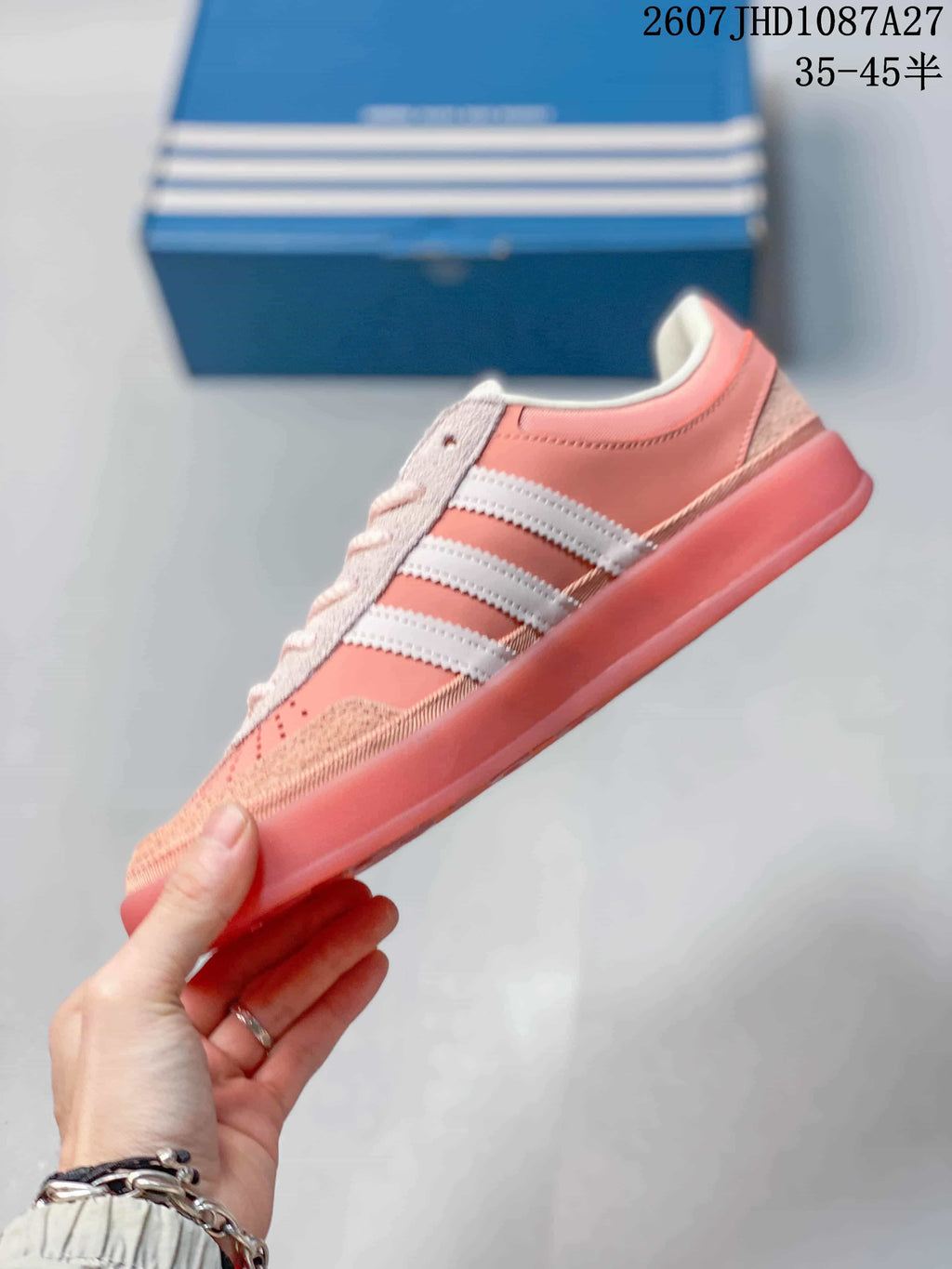 Side profile of the pink and white low-top sneaker with three-stripe detailing.