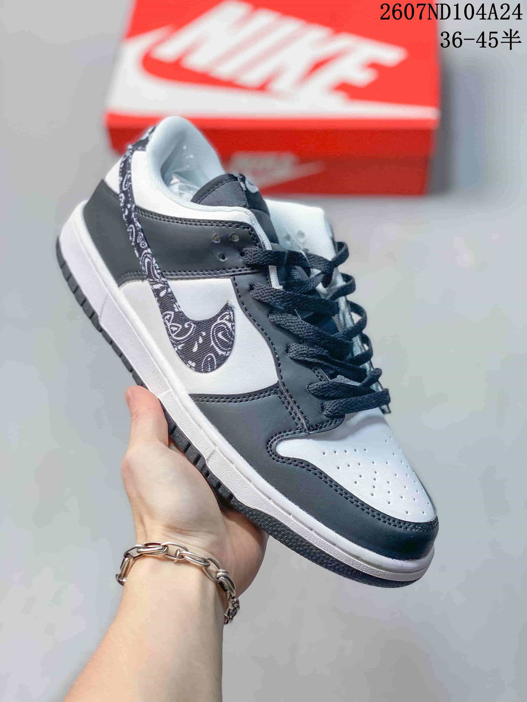 Close-up side view of a white and black sneaker with a patterned Nike Swoosh.