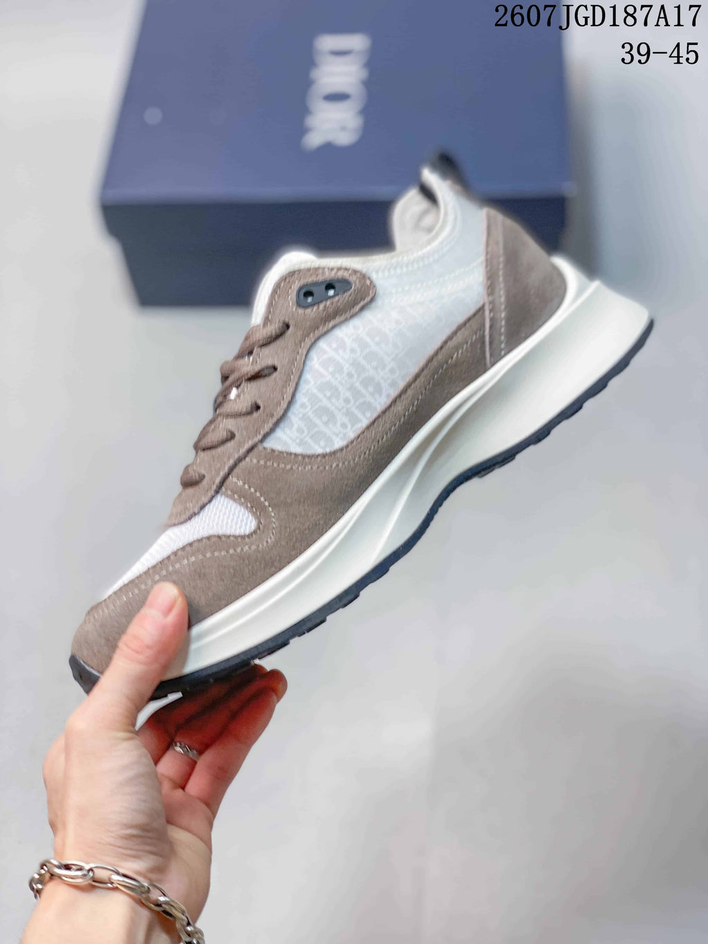 Side profile of the sneaker showing the patterned side panel, taupe overlays, lace-up construction, and layered sole.