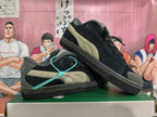 Pair of black Puma sneakers showing the taupe side stripes and grey accents