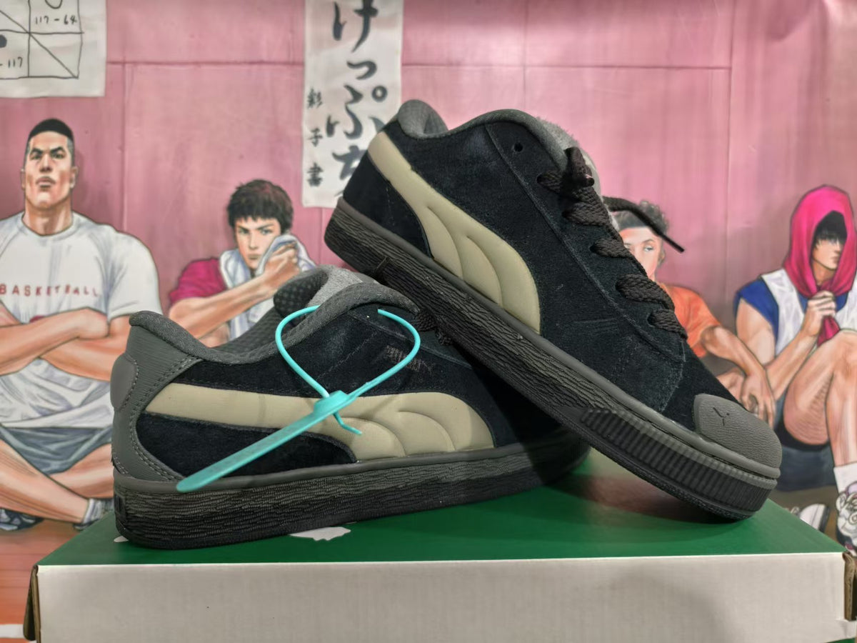 Pair of black Puma sneakers showing the taupe side stripes and grey accents