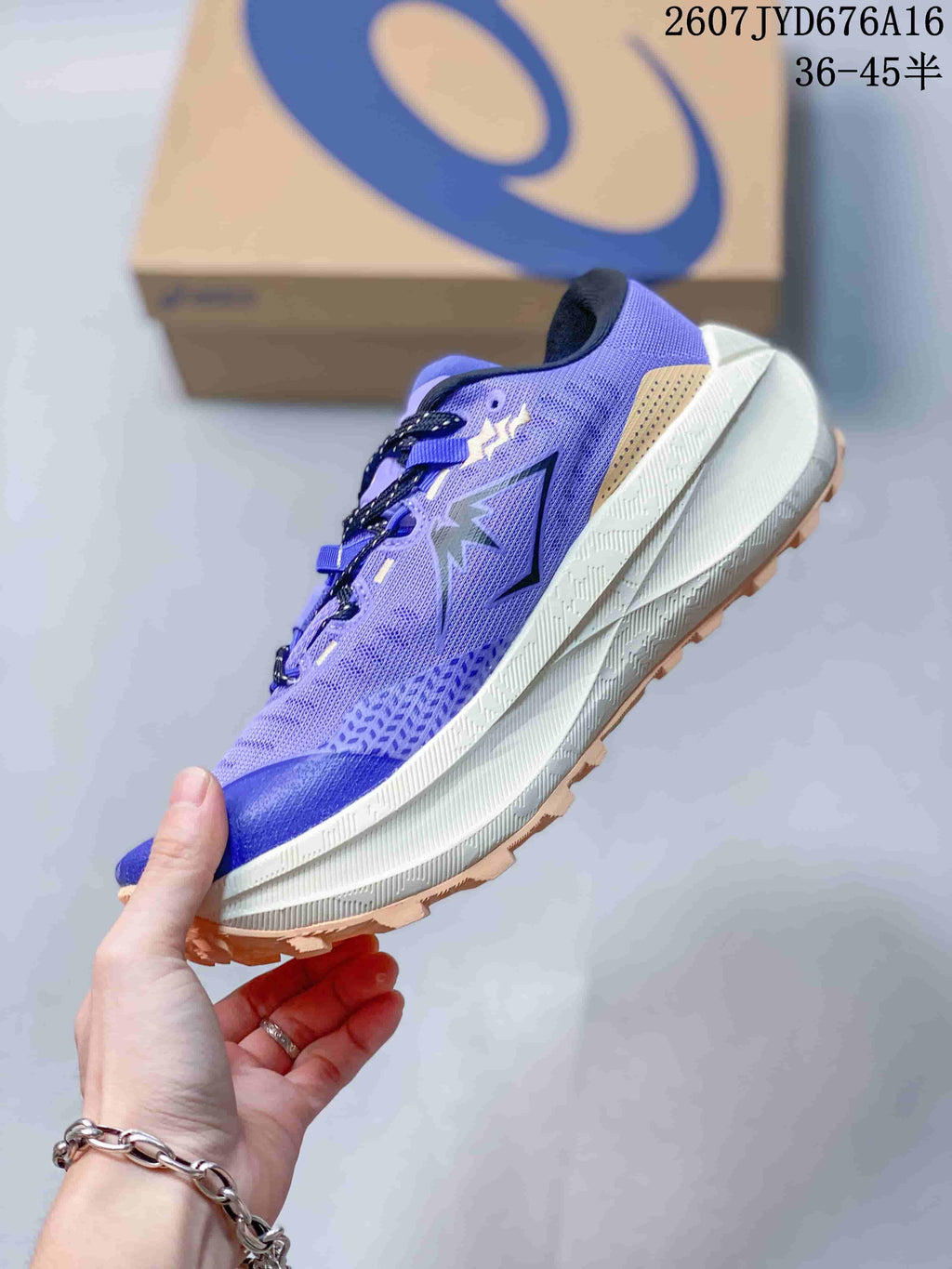 Side view showing the purple mesh upper, dark side branding, layered midsole and tan outsole.