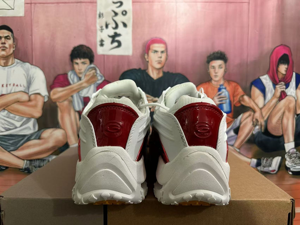 Rear view of white sneakers with glossy red heel panels and a sculpted outsole