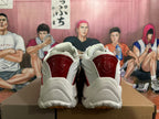 Rear view of white sneakers with glossy red heel panels and a sculpted outsole