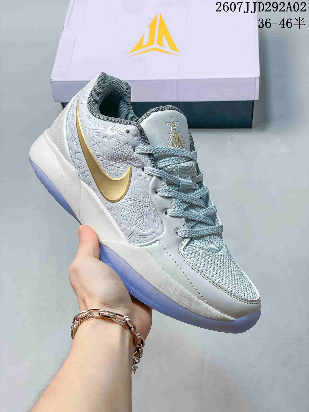 White and pale blue Nike JA 2 basketball shoe with a metallic gold Swoosh and translucent outsole.