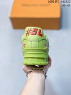 Rear view of the green sneaker showing the padded heel, decorative motifs, and layered sole.
