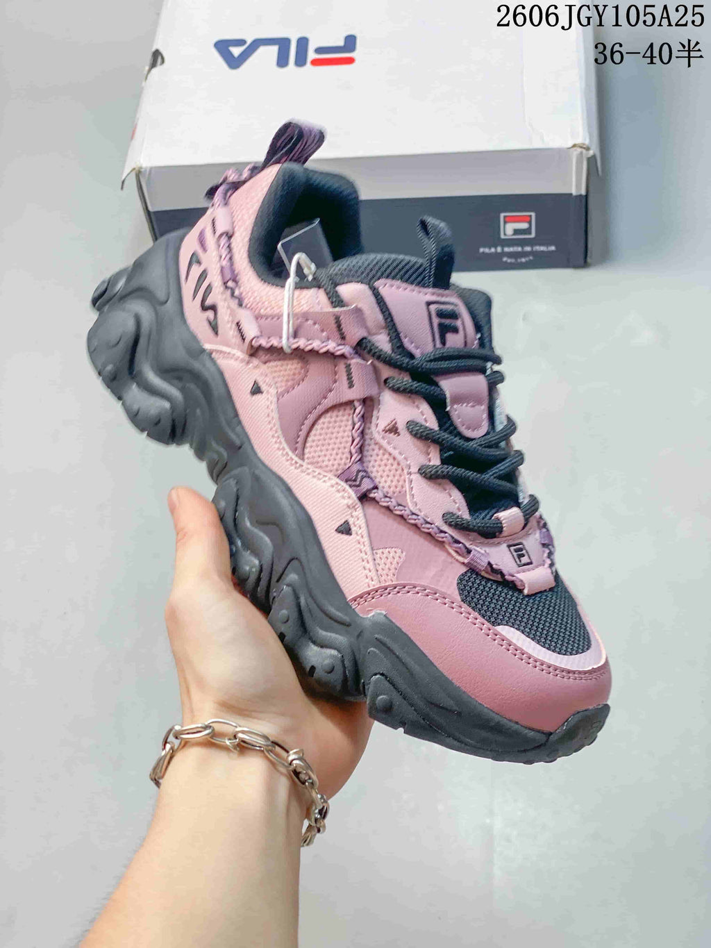 Angled view of the pink and charcoal FILA Fusion sneaker with layered panels and chunky sole.