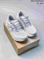 Pair of light gray and white On running shoes displayed on a tan shoebox.